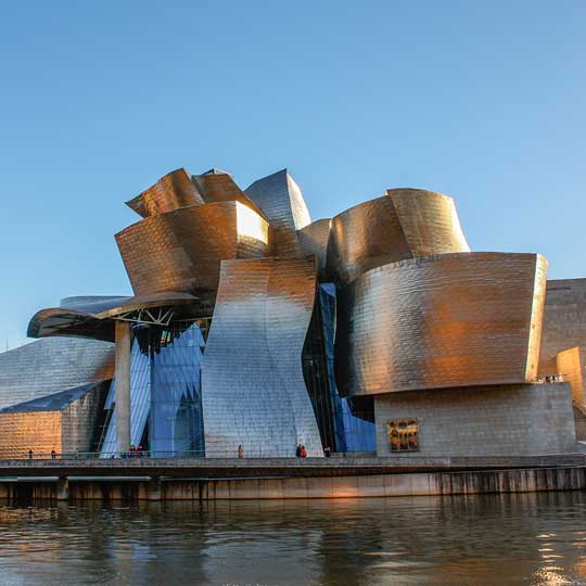 The Guggenheim Museum Bilbao, a curved metallic building beside the river